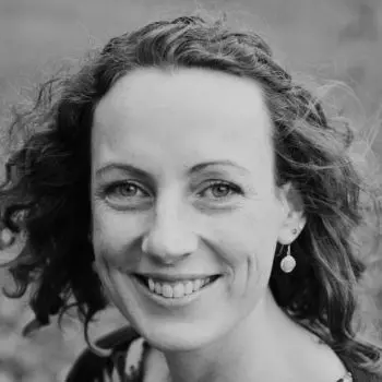 In a black, and white photo, a smiley scattered hair young girl | Style & Presence of Yoga