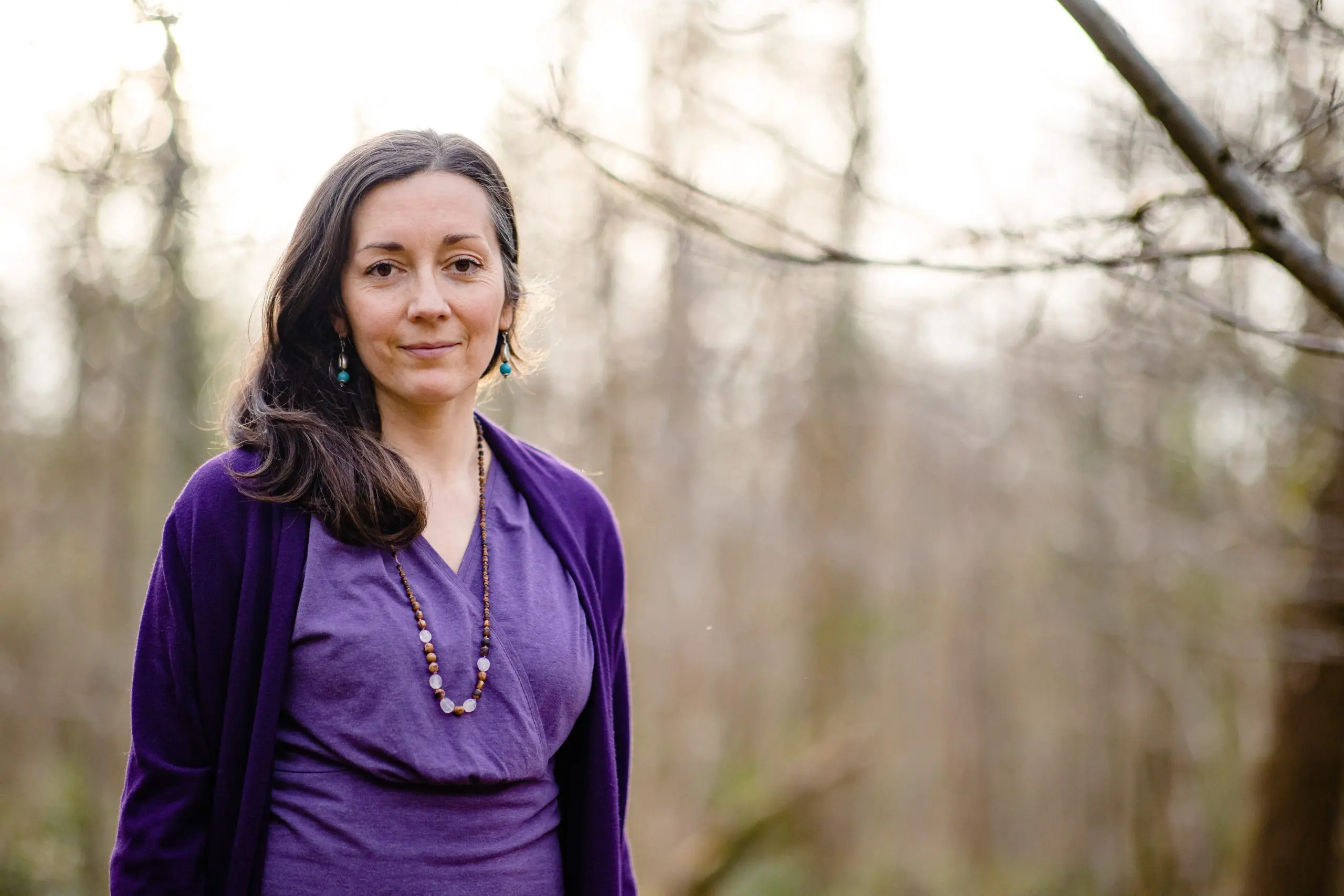 A long hair woman who wearing a blue color yoga dress & necklaces