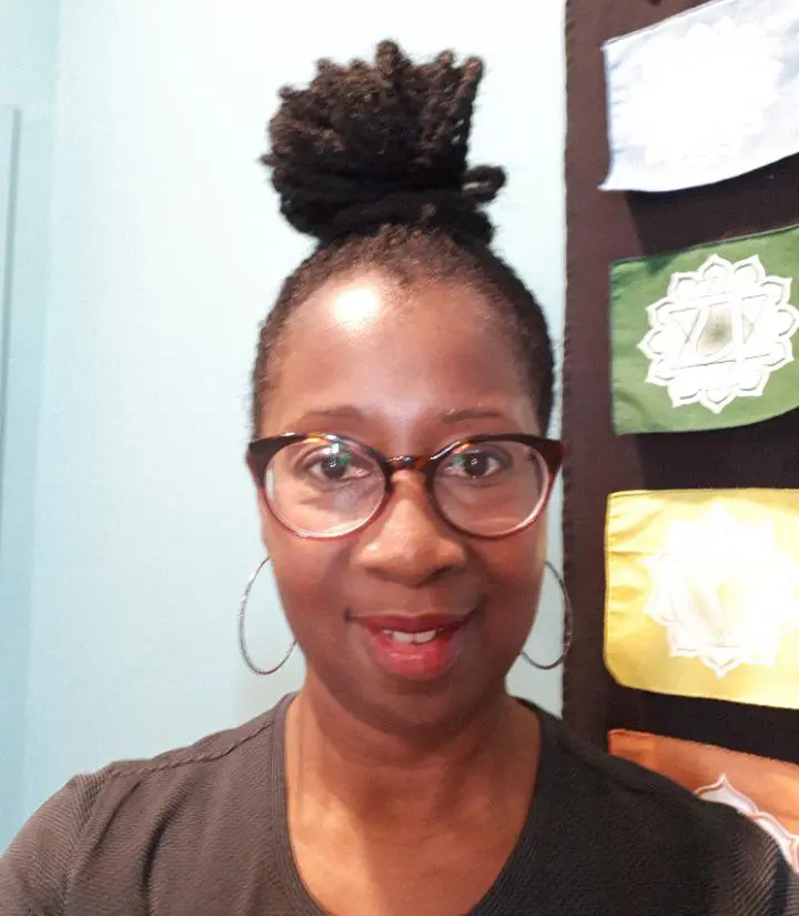 A young African lady, wearing glasses & her hair is curly