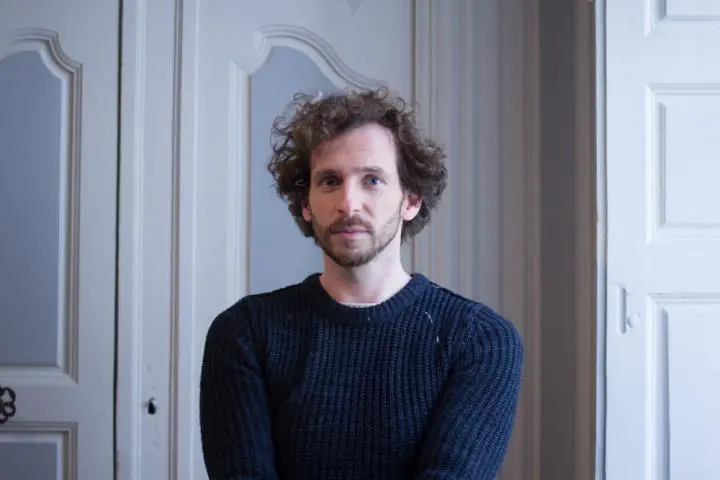 A scattered hair mail chiropractic teacher standing from the front of the massage room door