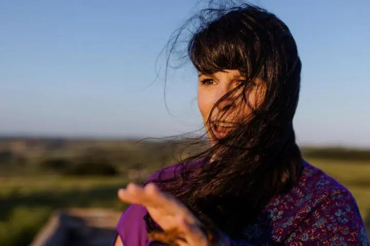 A young girl who her shiny & long hair blowing in the wind