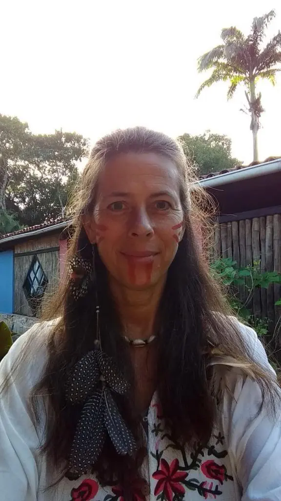 Long-haired terrible woman wearing native American-style black zircon feathered surrounded by natural background