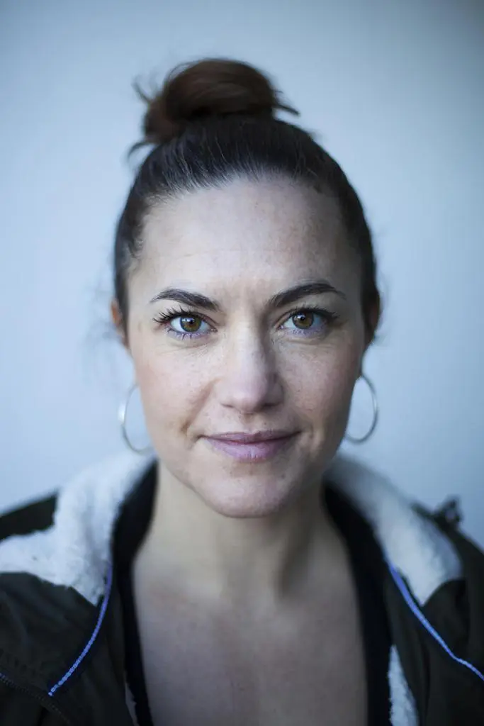 An adult yoga instructor who wearing a black jacket & Jhumke