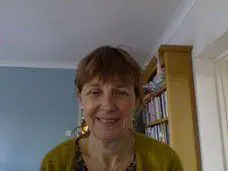 Little haired old woman standing in Yoga Nidra's room and her backside is a books Closet