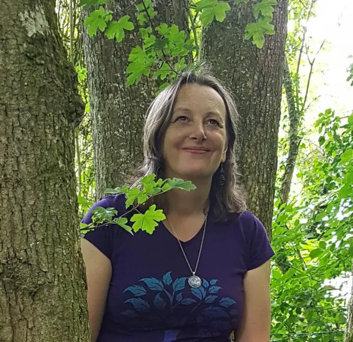 A 35-year-old woman looking awesome standing in the mid of two trees performing Yoga Mood-Boosting Activities