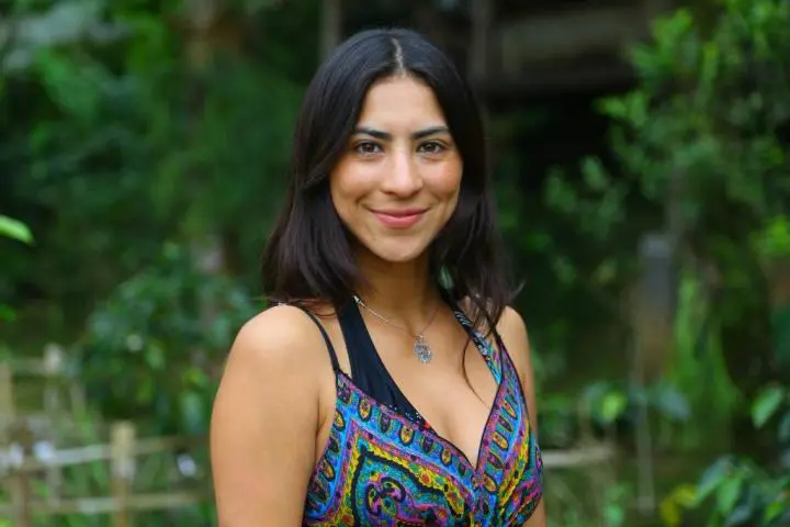 A long hair slim girl wearing two bras & smile with the background in green baller view