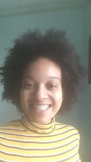 Laughing girl with an ugly smile and her curly hair standing upward