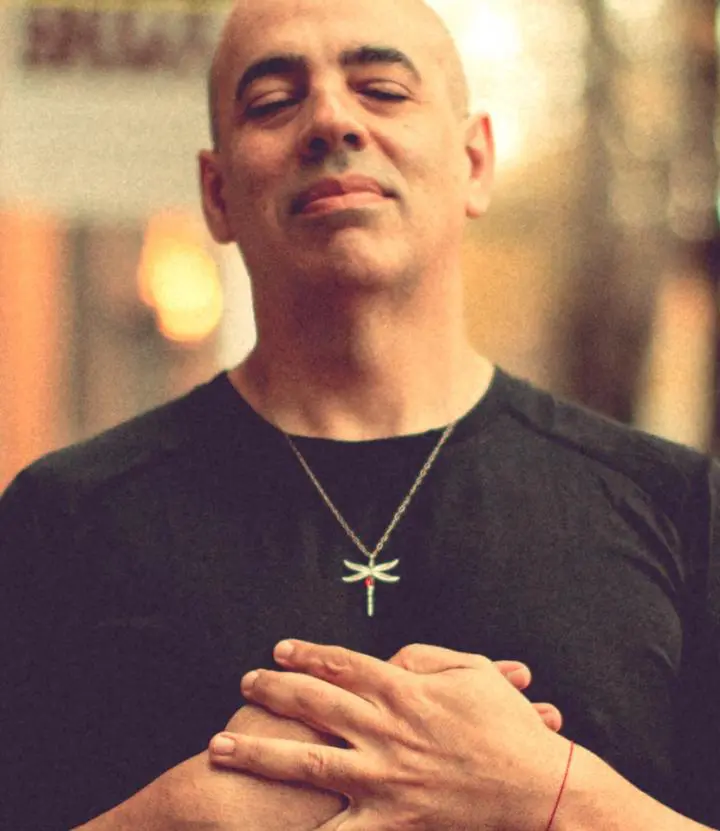 Bald man standing in the meditative yoga pose, with his holding hands as like stand in prayer