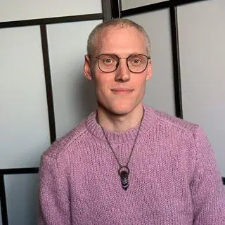 A bald man who wore glasses and a jersey standing in a cell | Mind-body exercise