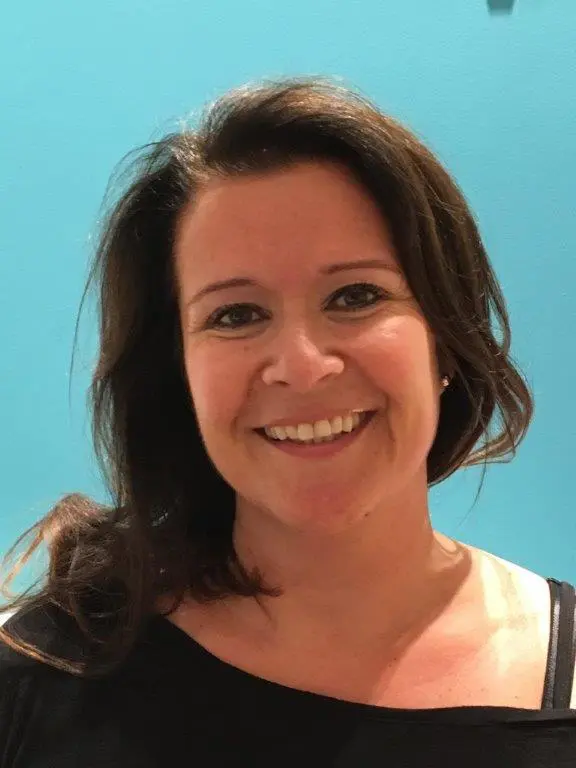An adult lady wearing a black shirt and she looking with regretful eyes at the Yoga Nidra platform