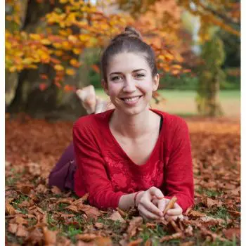 An adult girl lying in a garden leafs and she is happy after doing exercise and performing a yoga pose