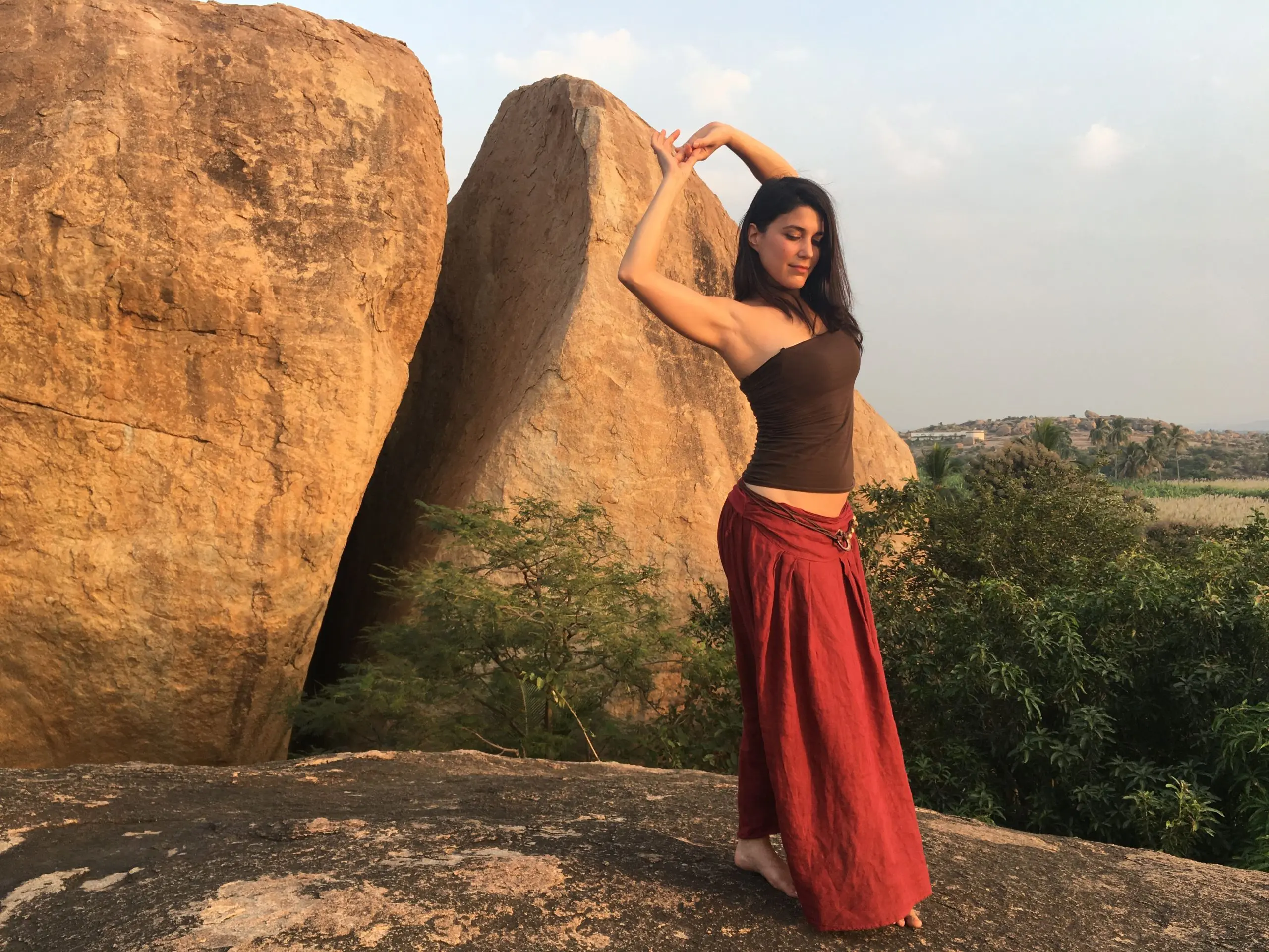 A young pretty girl standing in a Stacho practicing yoga pose, with their body twisted and their legs & arms extended