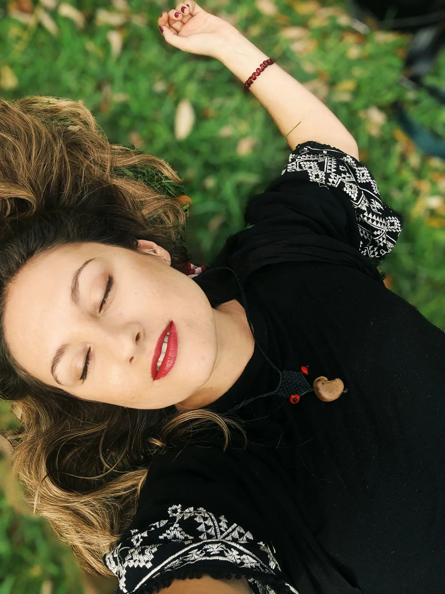 Such a lovely girl lying on grassy land with her scattered hair, she is tired after doing yoga