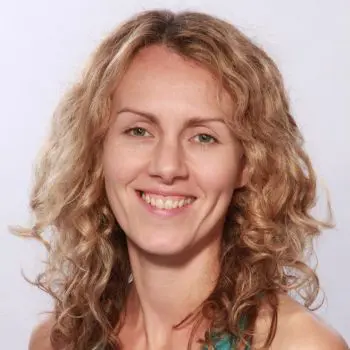 A female chiropractic instructor, her hair scattered & white-brown