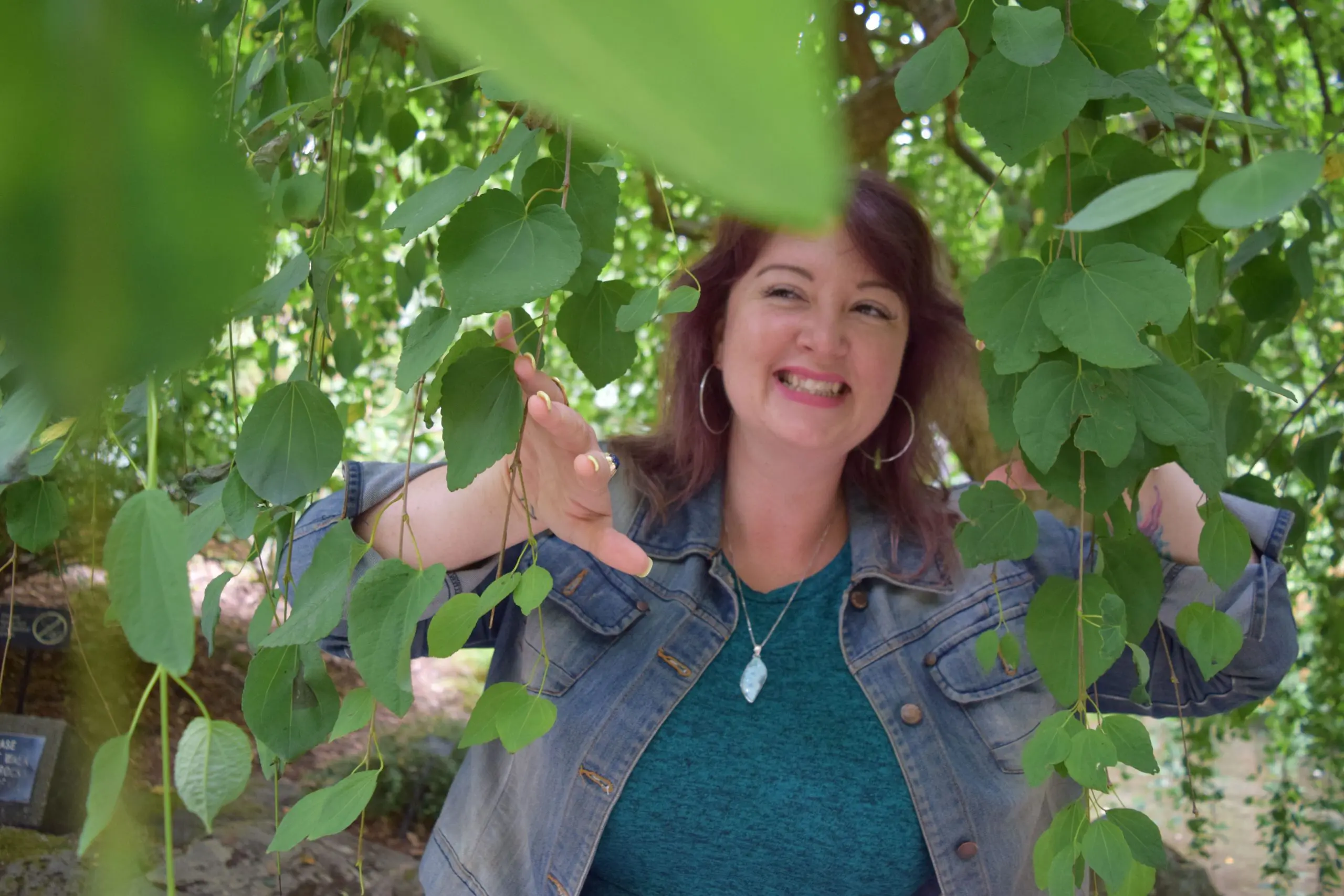 An adult lady standing between the leaves and wearing a blue jacket | Woman Therapy