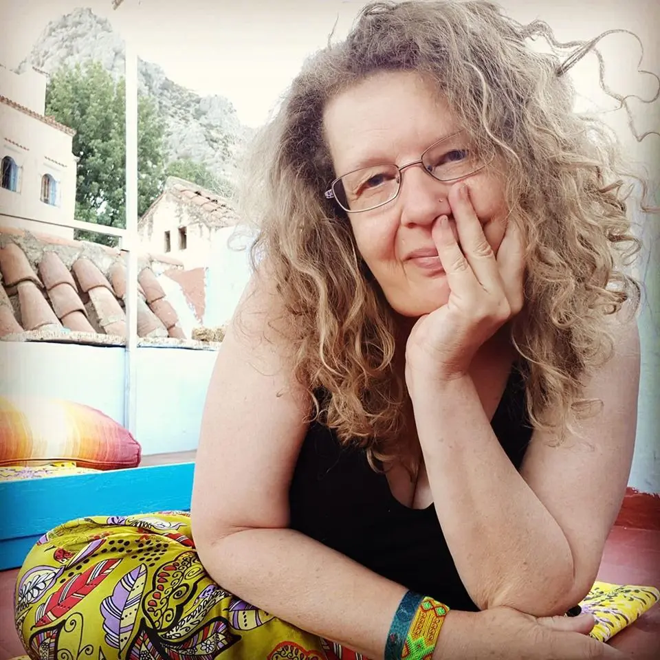 Brown scattered haired old woman seated in a yoga pose