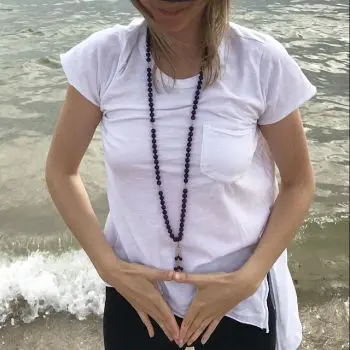 A Woman teaching a mind-body exercise at the beach of the ocean
