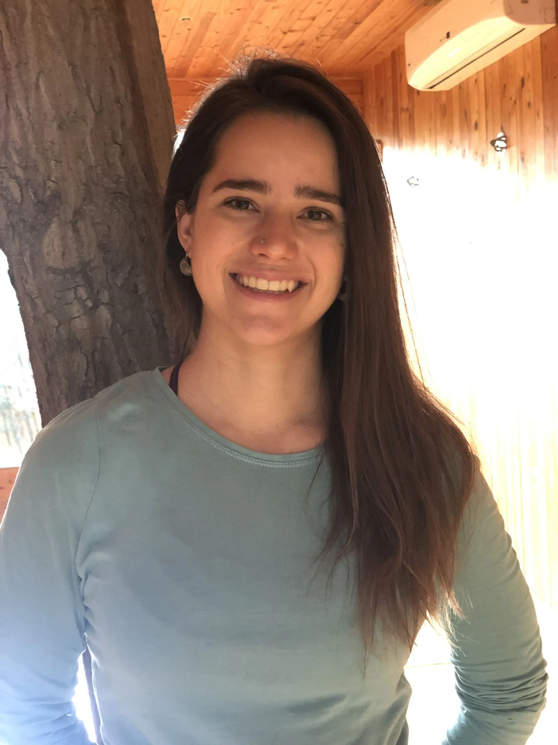 Such a beautiful girl is leaning on a tree and she is excited about yoga