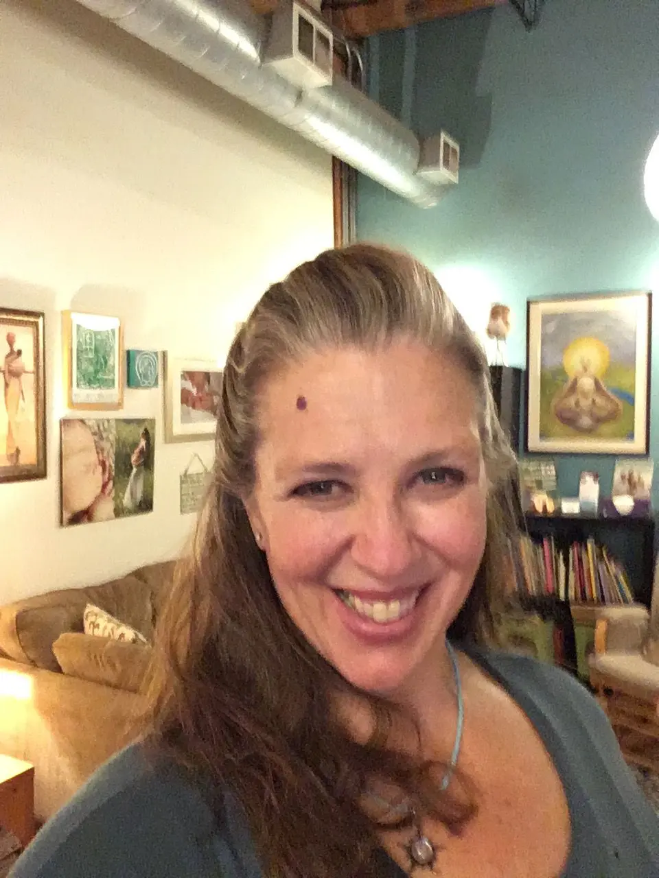 An adult lady smiling in her bedroom with their texture background | Woman Yoga Therapy