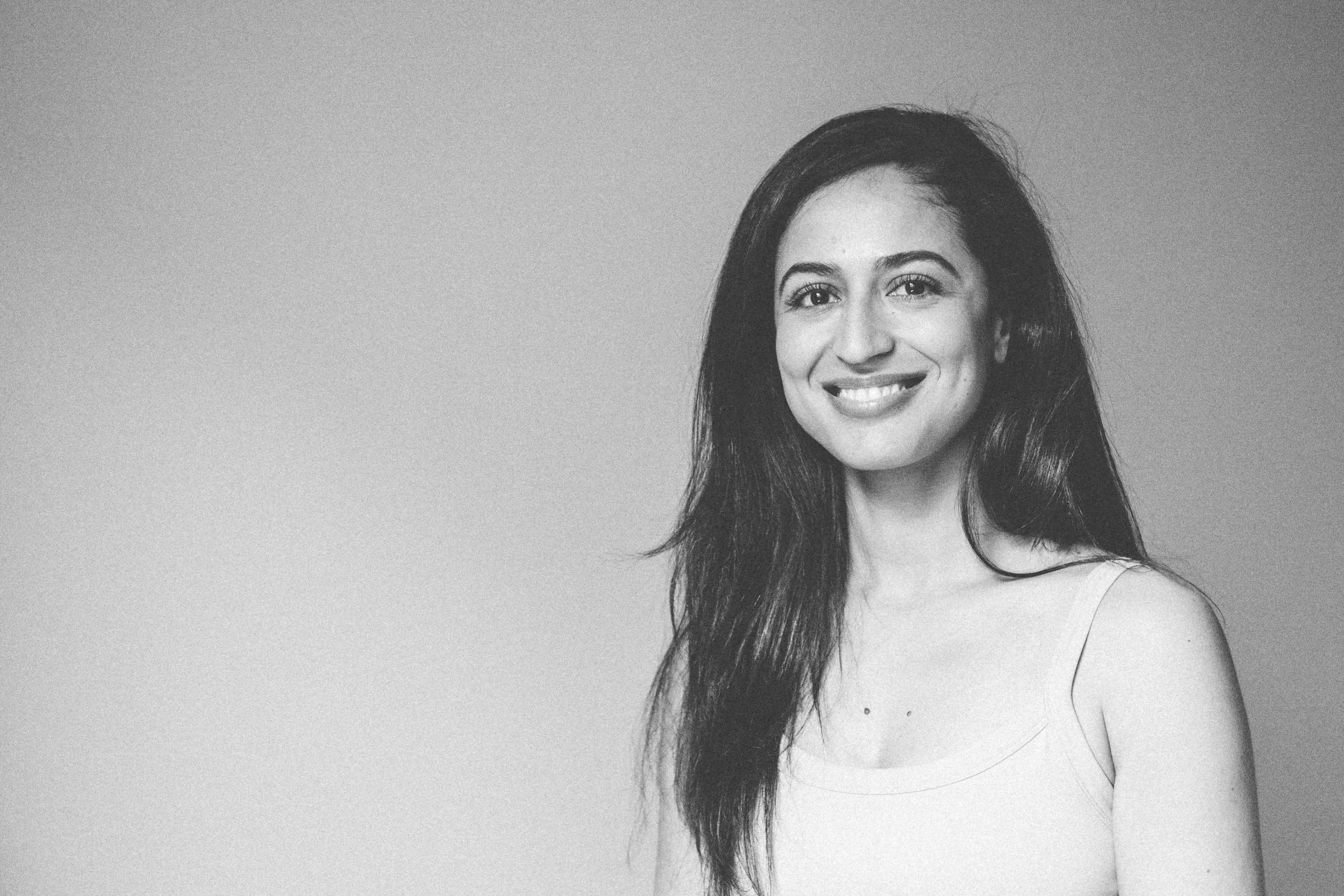 A Femail standing up with black in white background in yoga class