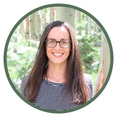 A smiley young girl wearing glasses who her long hair & is standing in the garden | Start yoga journey