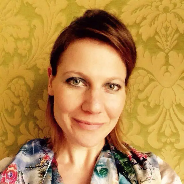 She is making a pretty hairstyle and wearing a yoga dress