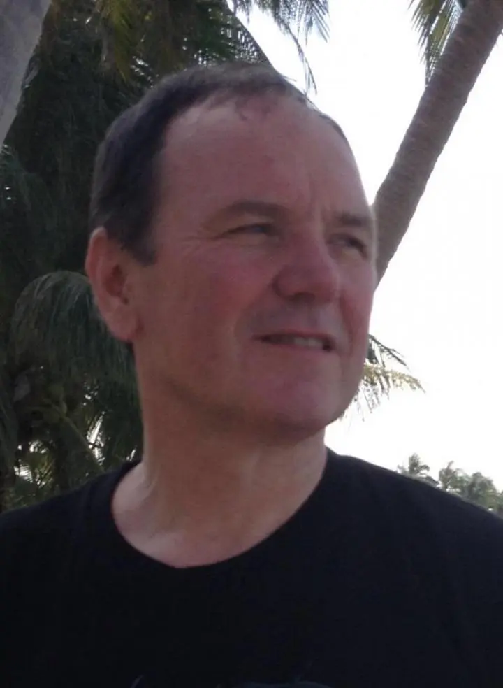 A 40+-year-old man standing below the palms trees | special yoga instructor