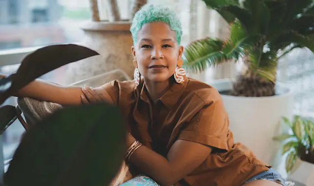 The African-white hair woman sitting on her sofa with their surrounded by textured background