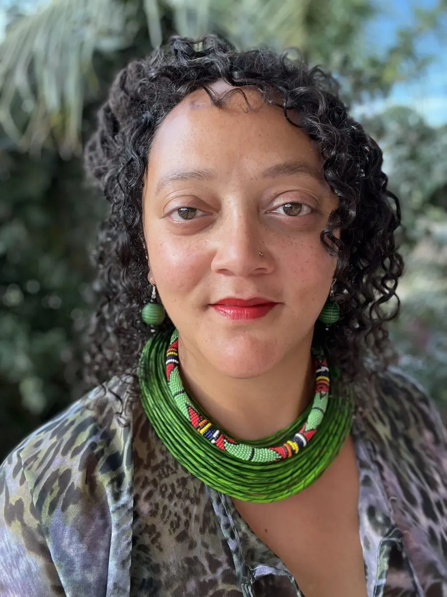 A smiley man tying a turban with clapping and wearing necklaces | Mail Yoga instructor