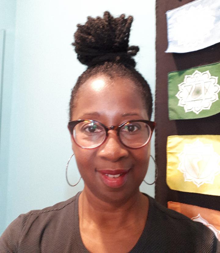 A young African lady, wearing glasses & her hair is curly