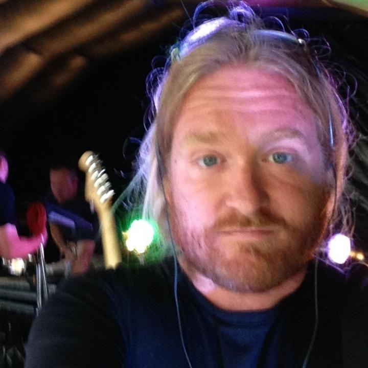 A brown beard man standing in a musical studio