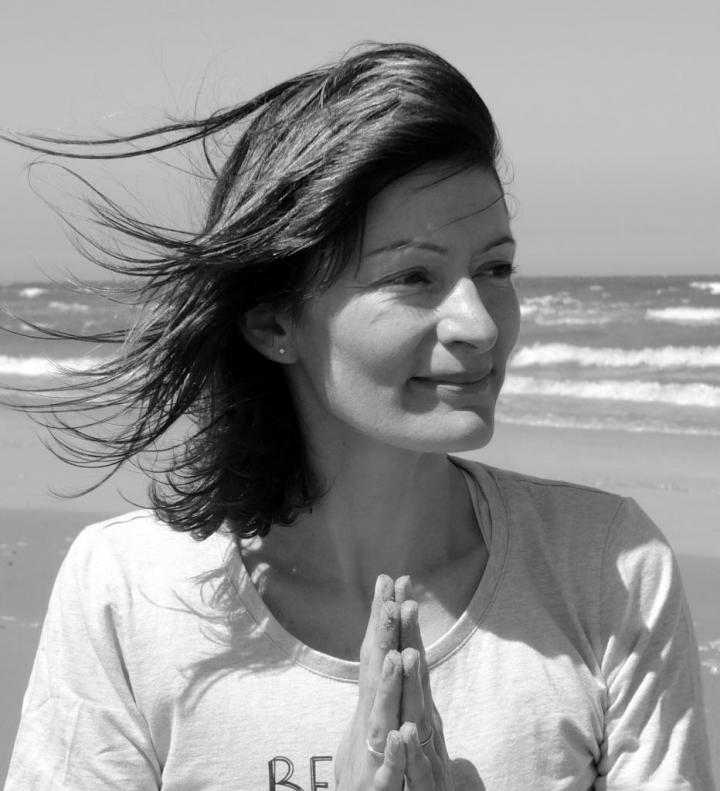 Such a beautiful girl who has Waving hair on the beach and standing in Yoga Pose