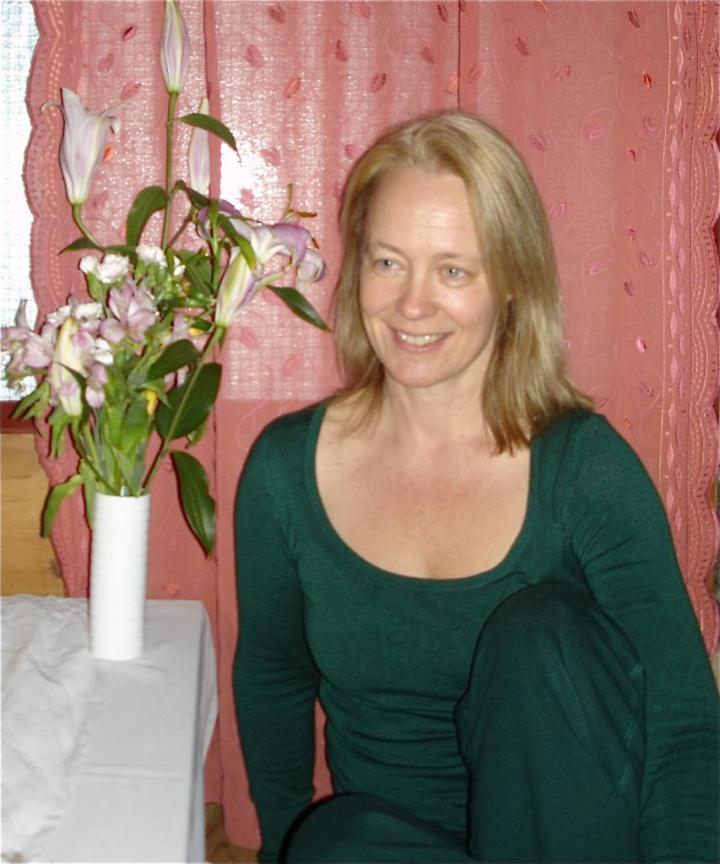 An old lady sitting in the massage room, with their on the table at a bouquet