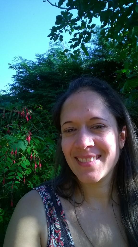 A smiley woman standing in bushes | Fitness Interventions