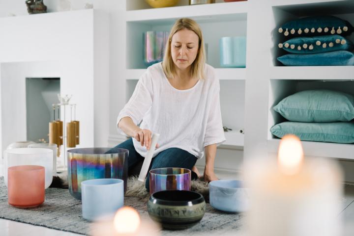 A lovely woman holding a swiper sitting in a kitchen surrounded by a texture room environment