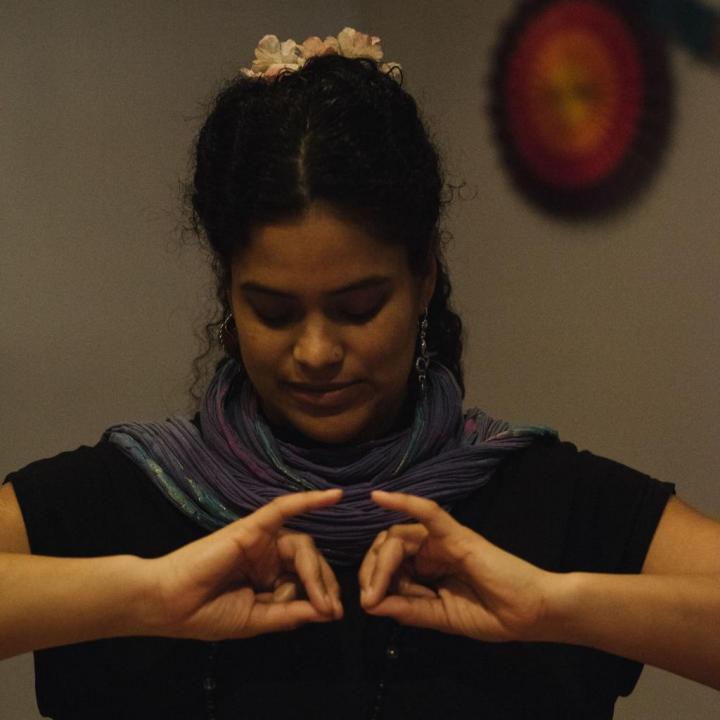 A smiley man tying a turban with clapping and wearing necklaces | Mail Yoga instructor