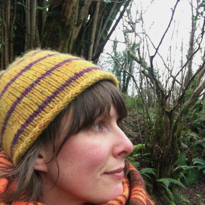 A pretty girl standing in the forest & is wearing piece handwoven scarf and head cap | Start your yoga journey