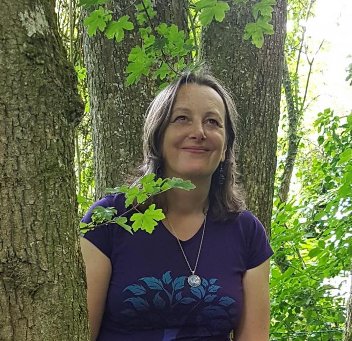 A 35-year-old woman looking awesome standing in the mid of two trees performing Yoga Mood-Boosting Activities