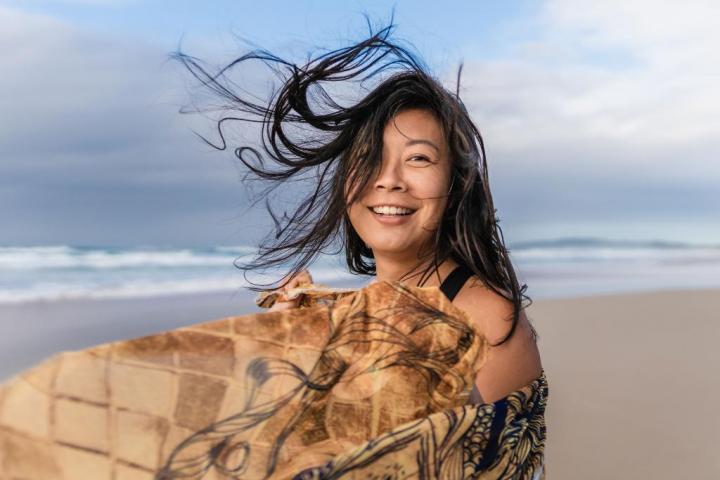 A smiling woman at the beach of the ocean