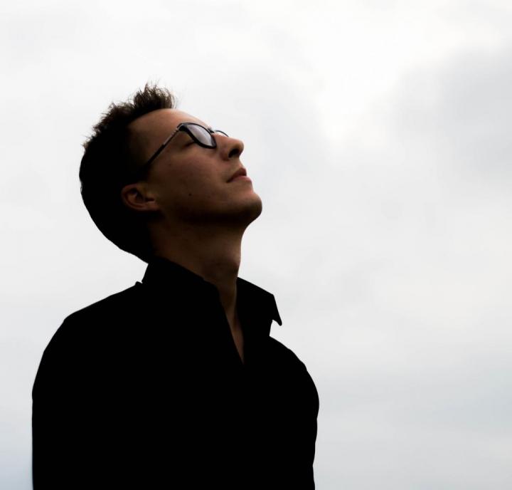 A glasses male yoga instructor feeling something and his face upward