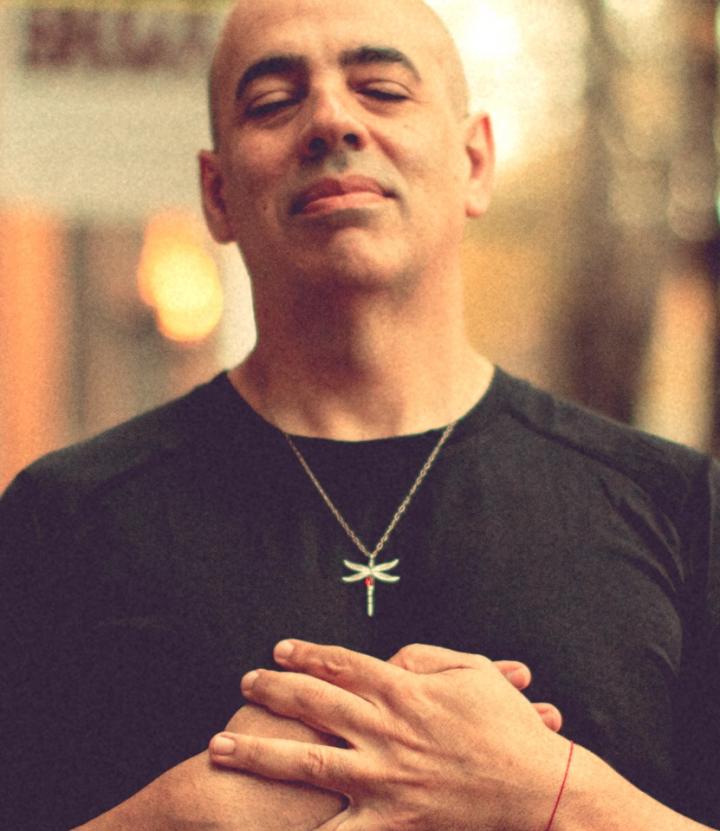 Bald man standing in the meditative yoga pose, with his holding hands as like stand in prayer