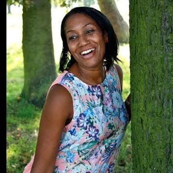 The black woman Yoga instructor standing with a tree in the forest