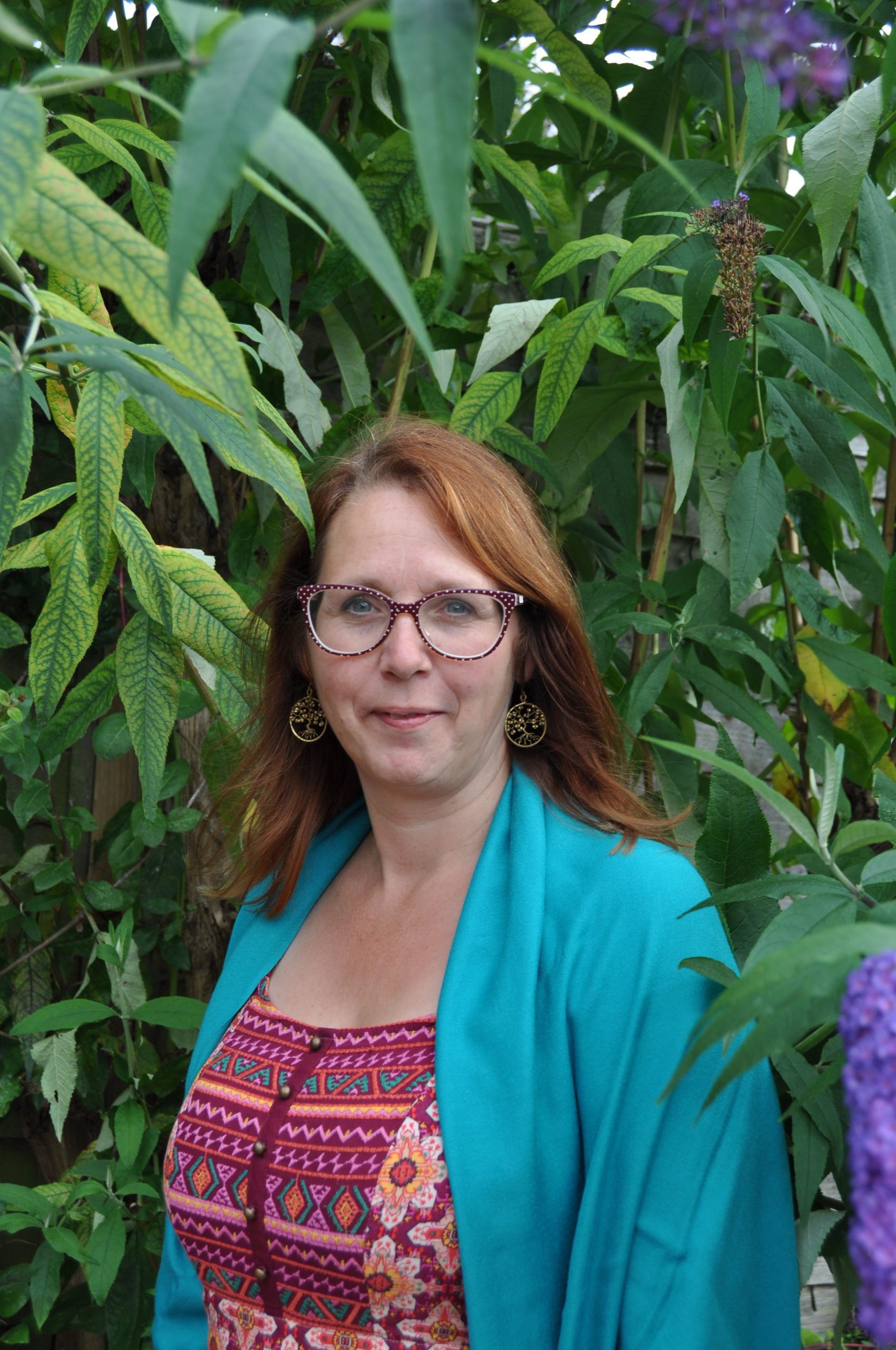 A pretty glasses woman standing between tree leaves who her big breast