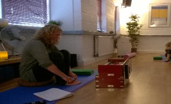 The old lady sitting in the massage room with her Yin Yoga poses in their textured environment