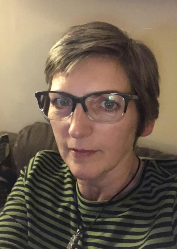 A glasses woman sitting on sofa | Yin Yoga journey